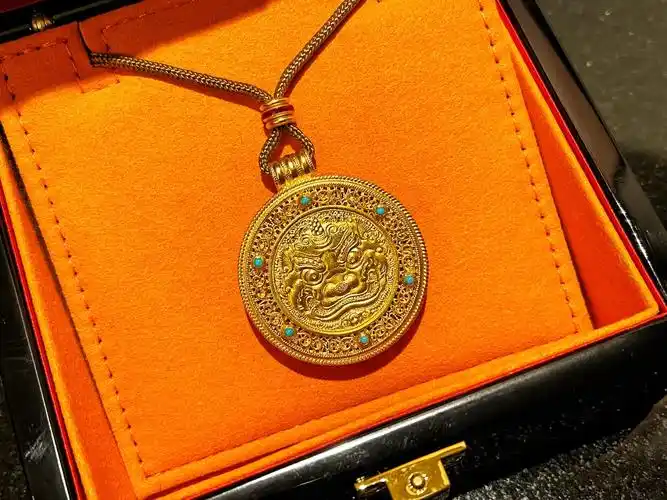 老铺黄金这款珊瑚版花丝镶嵌独角貔貅吊坠,正反面的花纹图案各有特色