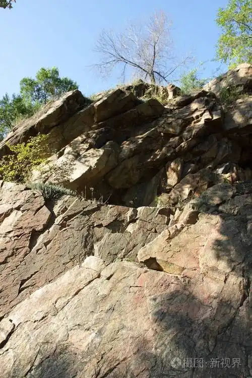在太阳下的花岗岩岩石花岗岩石的质地天然材料的背景远古时代的岩石