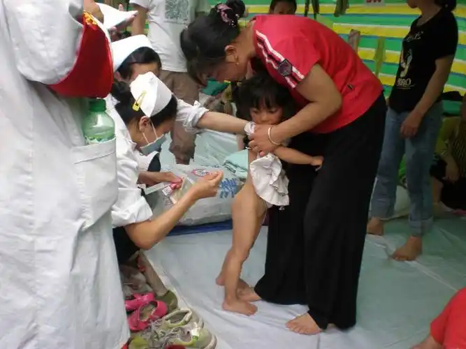 小女孩全身长满了疥疮,白衣天使正在为她小心翼翼的敷药.