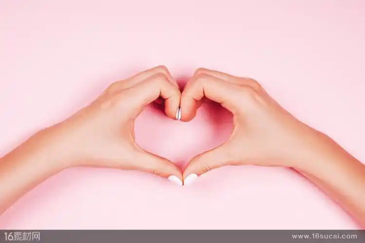 粉色背景上比心的双手高清图片