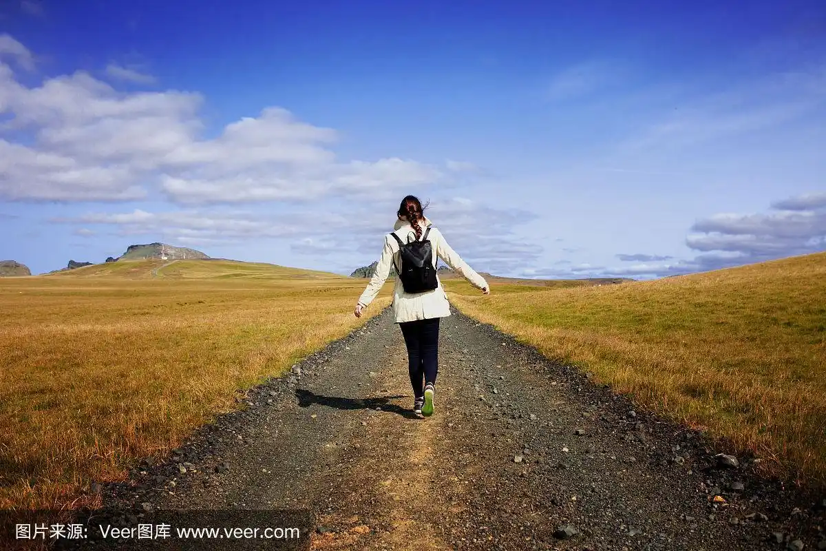 女游客背包在背景道路上.朝着我们的目标