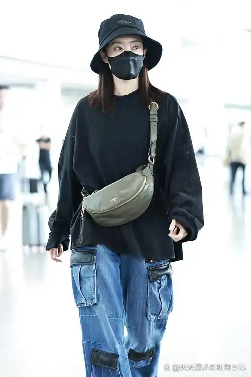 这是她最新的街拍,戴一顶黑色的渔夫帽,穿一件黑色的圆领卫衣,搭配