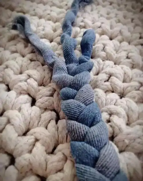 收口后把毛口反折,用针线固定这样一条用废旧牛仔裤做成的牛仔地垫就