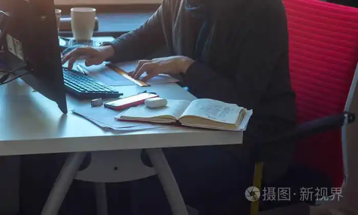 在桌子旁的女人在电脑旁工作照片-正版商用图片13fmag-摄图新视界