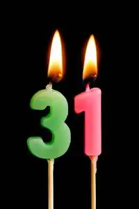 燃烧蜡烛的形式为31三十一 (数字, 日期) 的蛋糕孤立的黑色背景.