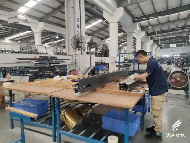 在亿合门窗车间,工人在忙碌作业.