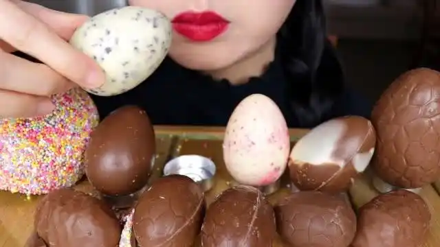 面对一桌子的巧克力蛋,小姐姐随手拿起吃一吃就感觉甜蜜无比