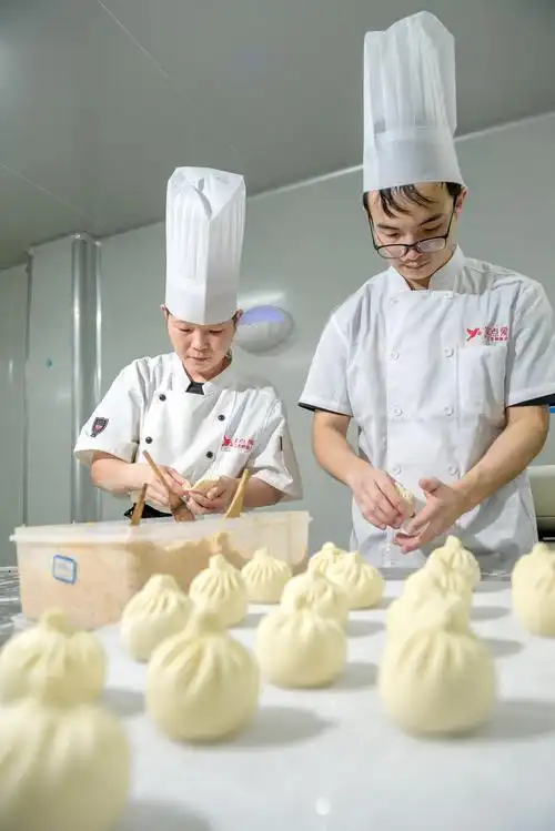 年纪最小的白案师傅刘佳正专心制作肉包.