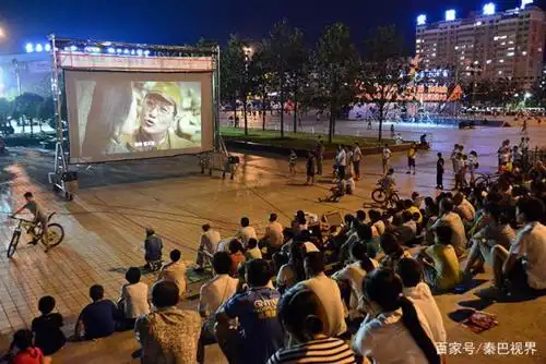 市民坐在露天广场看电影