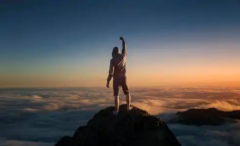 在云层之上的山顶上的人照片