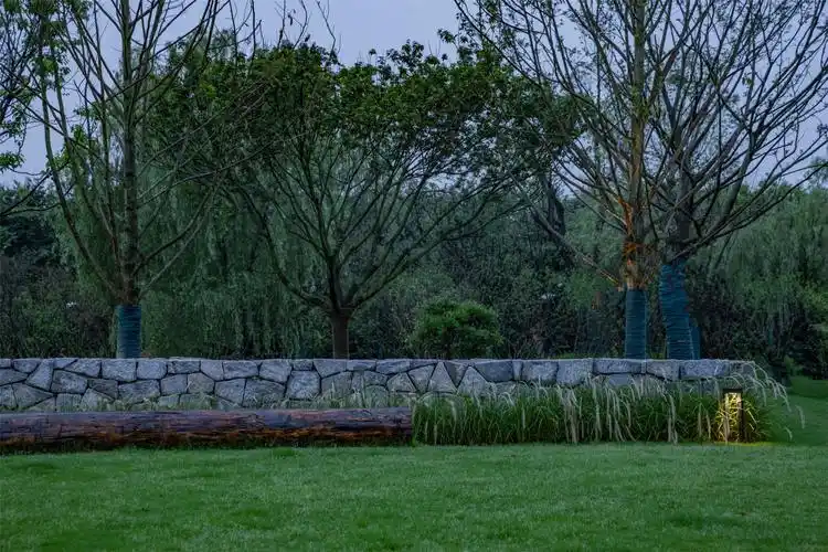 不刻意追求精致,仅用垒石矮墙,条形圆木,加以观赏草和景观灯点缀其中.