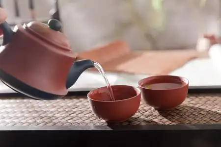 古代茶拿着茶壶倒茶照片