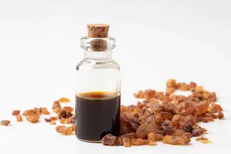 一瓶白色背景上有没药树脂的精油照片