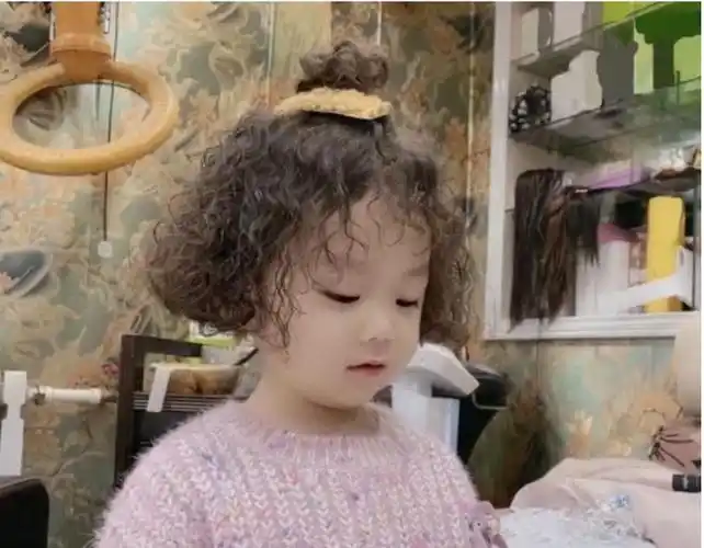 这位小女孩儿全头烫了羊毛卷,看起来时髦又可爱,白皙的皮肤搭配一丝丝