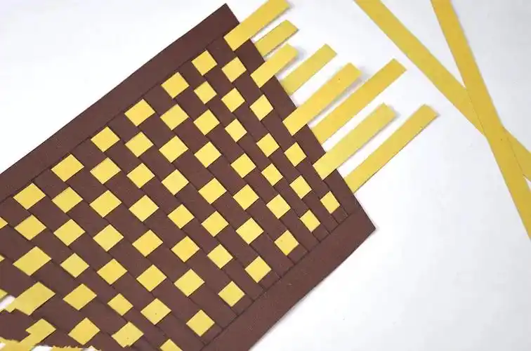 将纸条上下错落地编织进篮子里