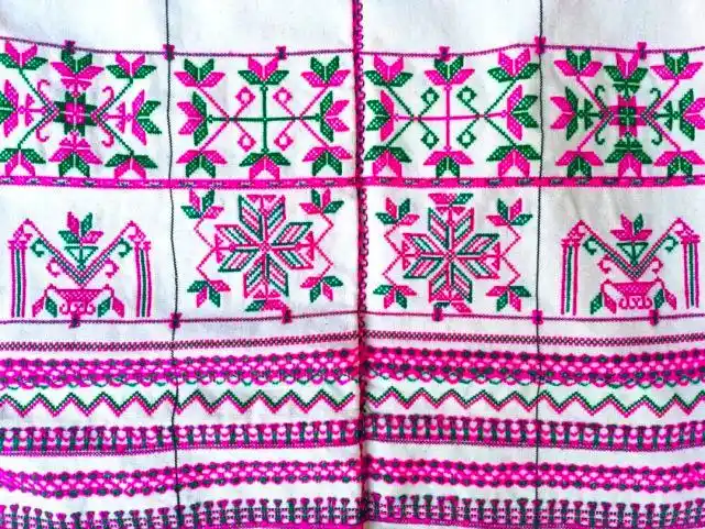 摆满了她亲手制作的各种哈尼族传统手工艺品和哈尼服饰图腾刺绣作品