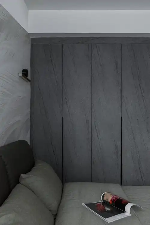 铁灰色的肤感膜柜门,花纹与床头背景墙的羽毛墙体并不突兀.