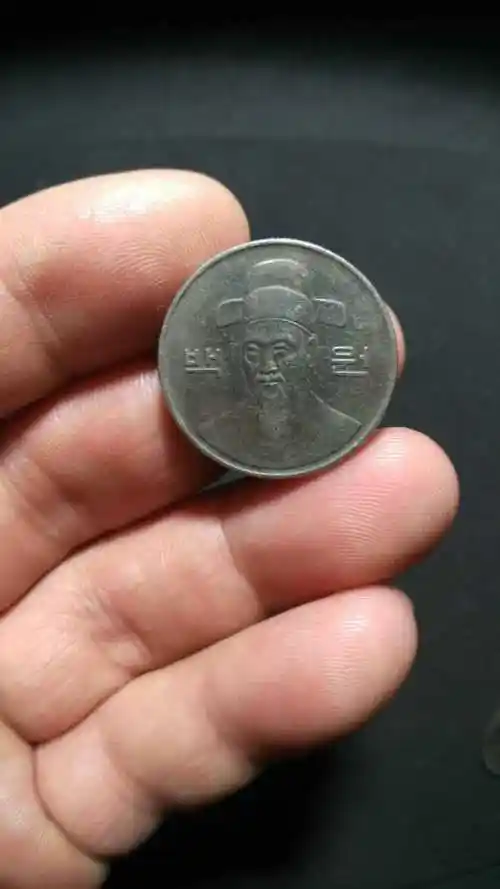 韩币官员头像,100元,灯光下