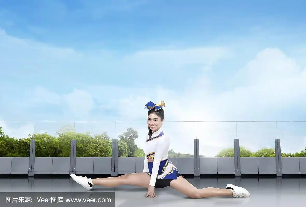 微笑的亚洲拉拉队做劈叉