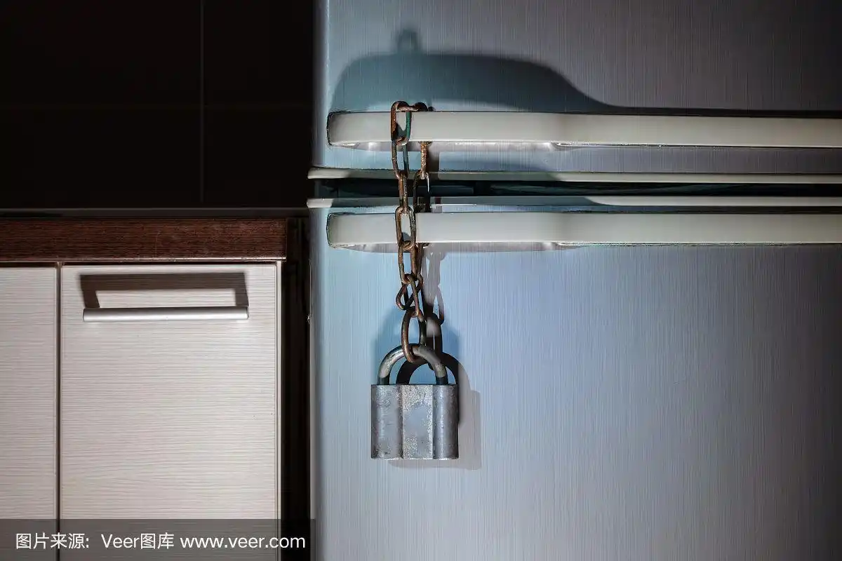 把冰箱锁上.冰箱上挂着金属挂锁.晚上吃饭,减肥,肥胖的概念