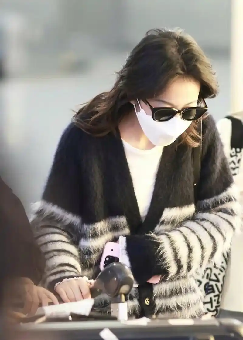 周雨彤机场街拍穿搭 这一次,穿了一件条纹开衫 搭配一条牛仔裤 整个