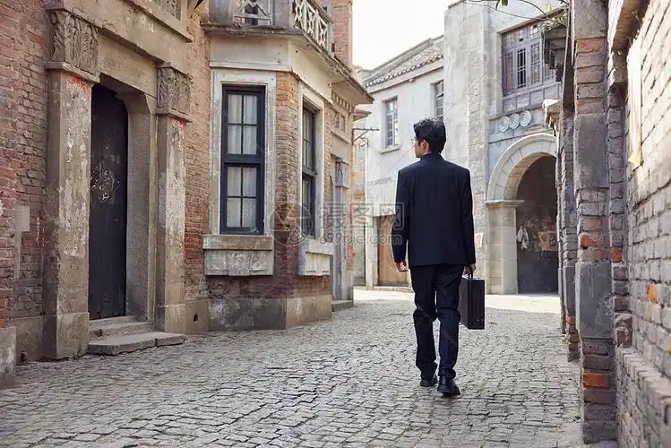 穿着中山装走在老旧街道上的男青年