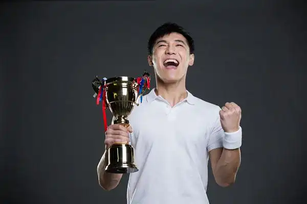 年轻男子拿着奖杯欢呼