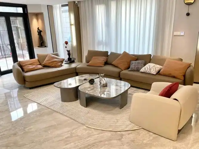 奶茶色瓷砖暖咖色皮质沙发与米白色圈圈绒螃蟹椅虽然和谐但是宽阔的