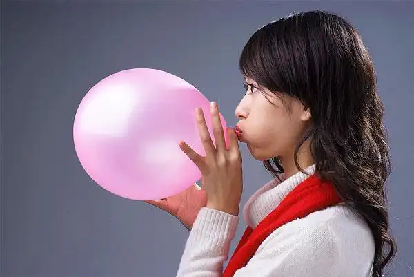 吹气球的年轻女人侧视图