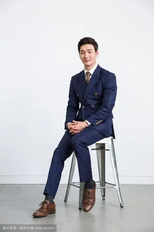 穿着西装的男人用姿势坐在椅子上的摄影