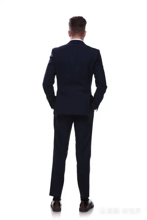 宽松的商人在海军西装站在白色背景手放在口袋里的背部视图