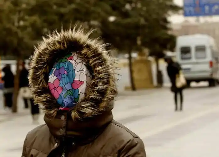 22日,北京遭遇今春第二场沙尘暴侵袭,街头行人"全副武装"应对