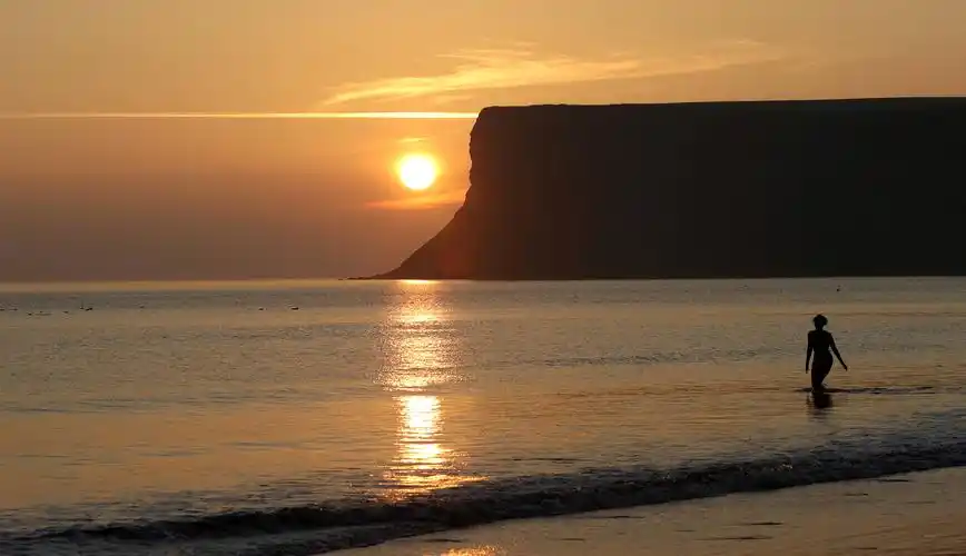 9月7日,人们走在英国索尔特本日出时分的码头.