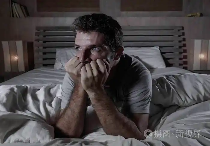 躺在床上的年轻迷人悲伤和沮丧的男人的戏剧性肖像感到焦虑抑郁焦虑