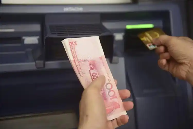 7月31日,储户在海南琼海的一处银行自动柜员机前办理业务.