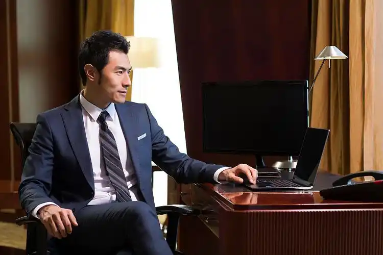 成功商务男士在书房使用笔记本电脑图片