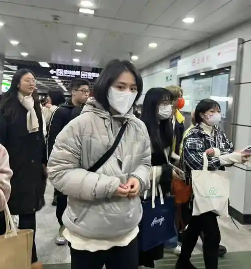 坐在地铁上的她穿着一件米色针织衫,展现了她普通身材的魅力.