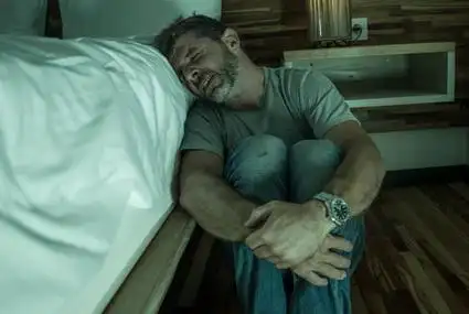 孤独的男子坐在卧室地板上哭生病遭受焦虑危机和抑郁问题感到无助照片