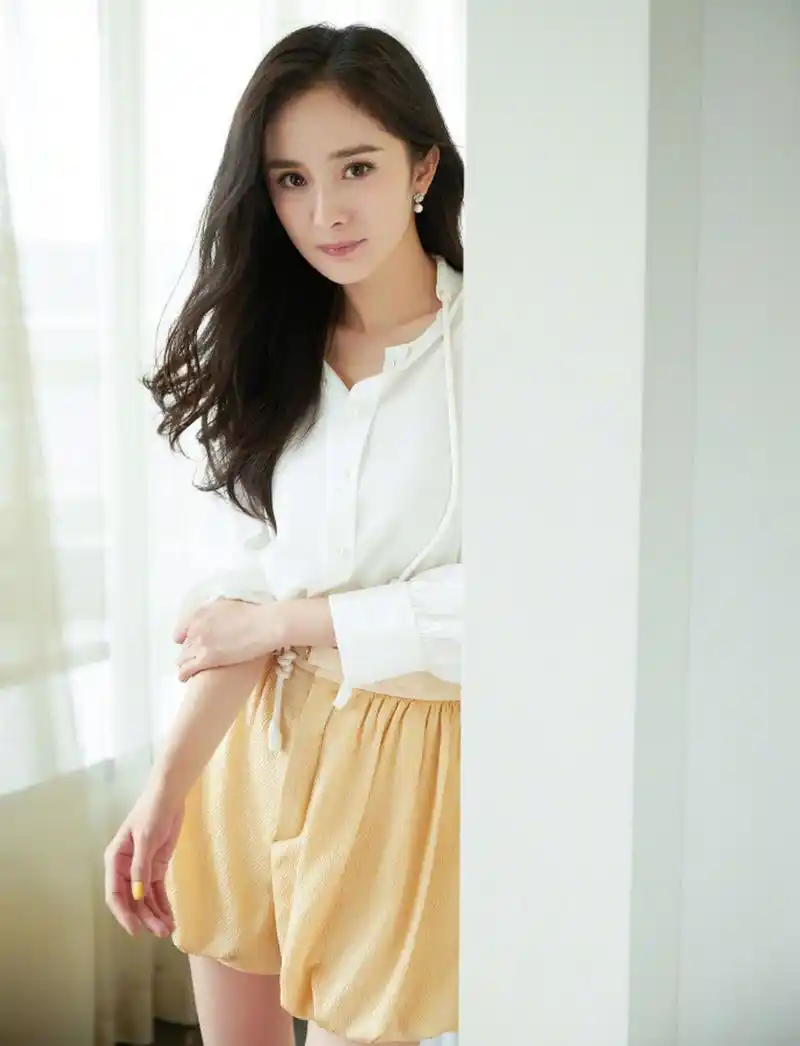杨幂一组最新活动造型,柔大波浪卷发搭配纯白真丝衬衫,金色灯笼短裤既