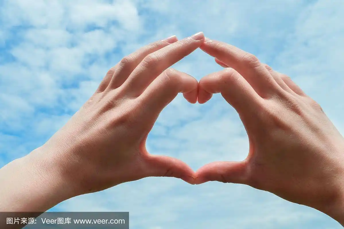 女性双手向蓝天伸出心形的手势