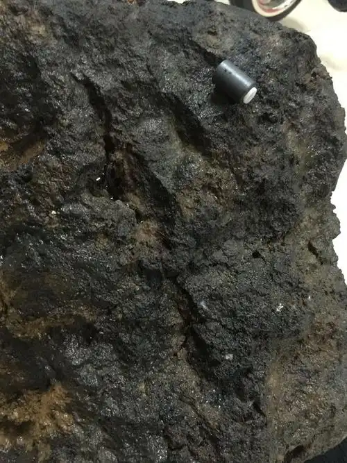 大家看看这是陨石?还是炉渣?夹着有垃圾图片可见.发现是在河边.