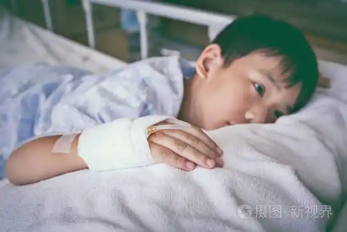 亚洲小孩手上躺在病床上,生理盐水静脉注射 (iv)