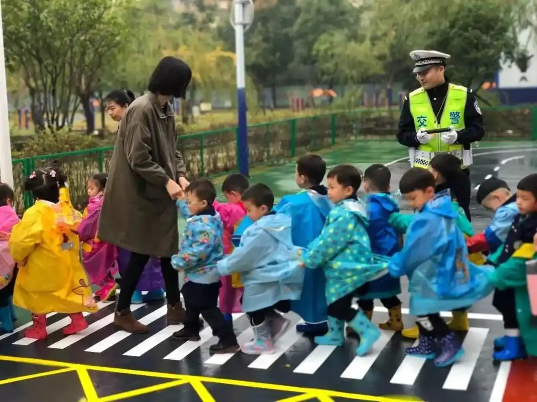 幼儿园老师带小朋友过马路,社会秩序教育意义重大,要从娃娃抓起_孩子