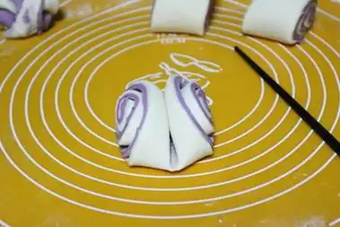 拿起面团两手各捏一头反方向拧几下将拧的两端收口向下,即完成花卷的