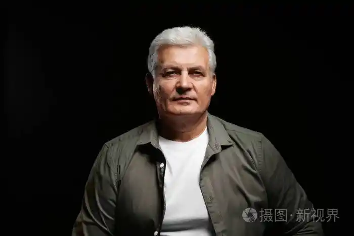 在黑色背景下穿着便服的帅气老人