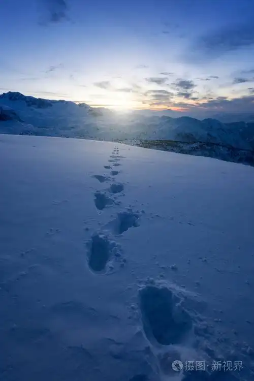 日出前在雪中的人类脚印在山顶上. 达赫斯坦·奥特里亚欧洲.