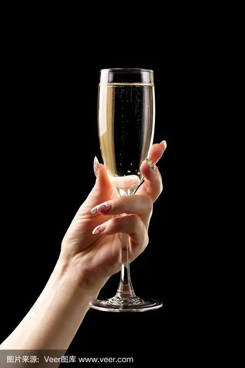 黑色背景上的女性手拿香槟酒杯.
