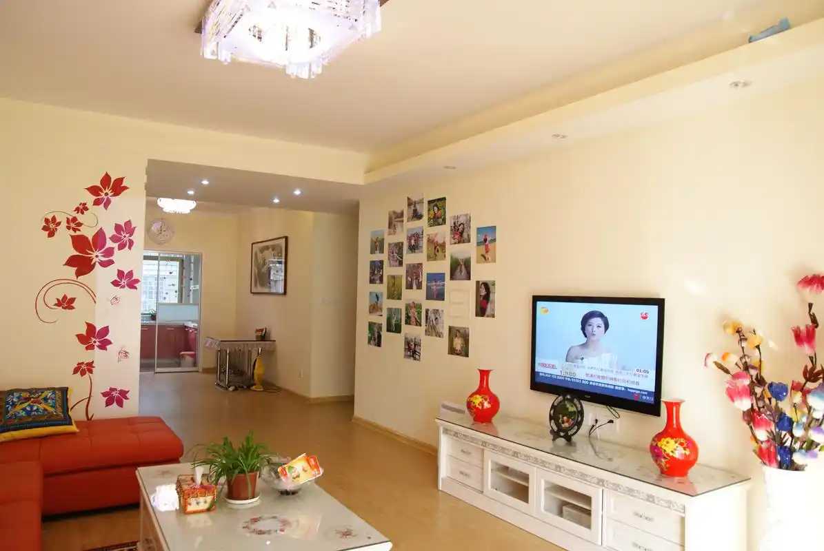 电视背景墙并未做过多建筑处理,乳白色原墙左侧,diy照片墙盛满了回忆