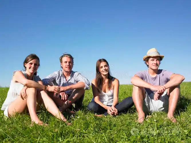 四个人坐在草地上
