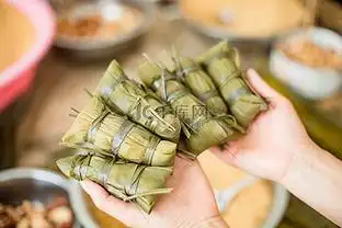 手捧粽子端午节一个人室内手捧粽子摄影图配图